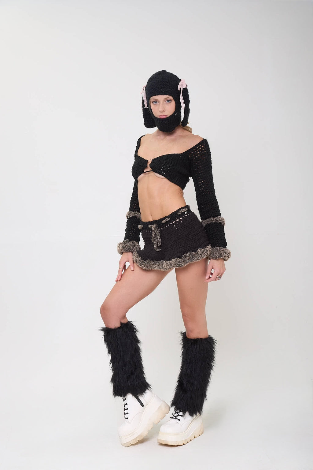 Model wearing the Not Your Baby mini skirt as part of a black outfit on a white background