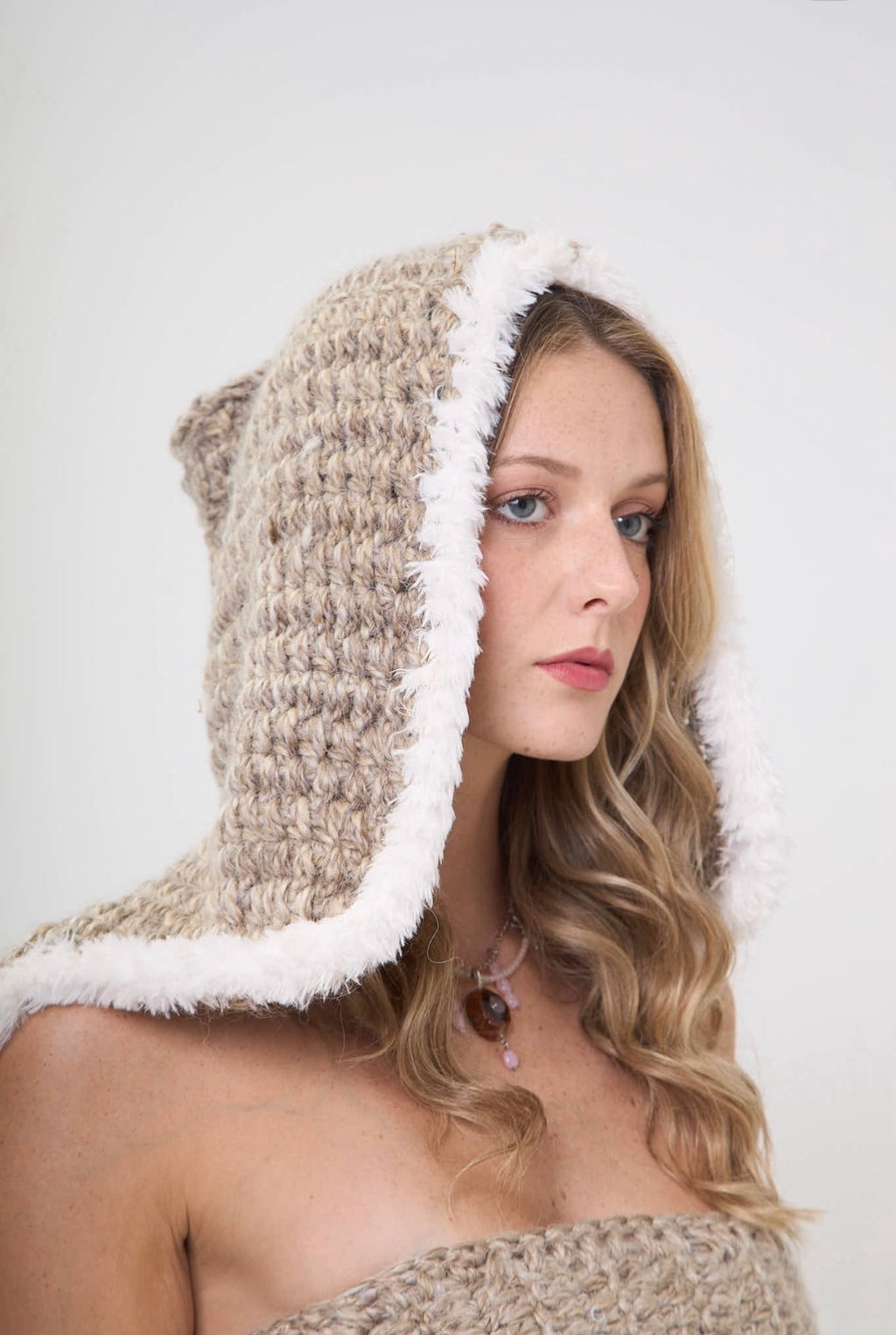 Side view of handmade crochet sand storm headcovering with fur trim